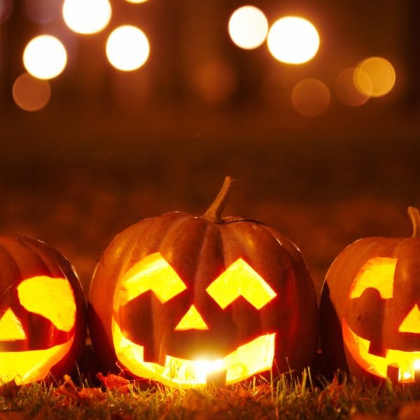 Three jack-o-lanterns at night.