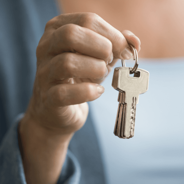 A woman holding up keys.